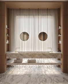 an elegant bathroom with marble counter tops and two round mirrors on the wall, along with built - in shelving