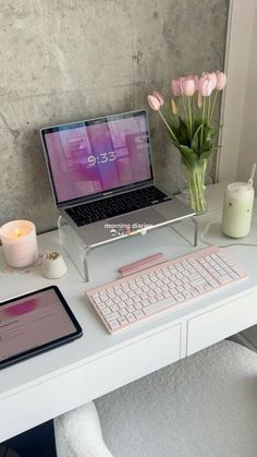 a laptop computer sitting on top of a white desk next to a keyboard and mouse