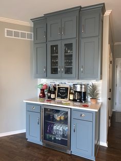 a kitchen with gray cabinets and an ice chest in the center, filled with drinks