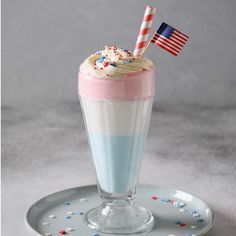 a patriotic drink with sprinkles and an american flag in the cup on a plate