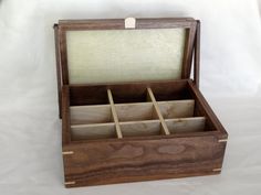 an open wooden box with compartments on the inside