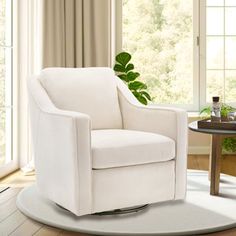 a white chair sitting on top of a wooden floor next to a table with a potted plant