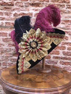 Historical tricorn hat with plumes, richly decorated. Complete your dress with this wool hat, created in our Atelier in Venice. Our tricorn-hat are made of wool and metal and are suitable for any size. They match perfectly with wigs. However you can wear them also without wig. All our hats are hand made and hand-decorated in our Atelier. This hat has been decorated with feathers, Swarovski crystals, trimming, lace. Size: please, choose the measure of the circumference of your head. Also, at the Venetian Costume, Tricorn Hat, Venice Mask, Rooster Feathers, Historical Women, Venetian Mask, Original Dolls, Man Hat, Pirate Costume