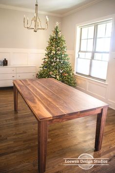 a wooden table sitting in front of a christmas tree