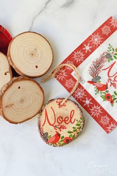 some wood slices are sitting next to each other on a white counter top with a red and green christmas ornament