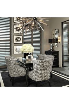 a black and white dining room with chandelier above the table in front of two chairs