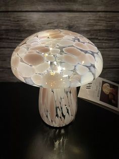 a mushroom shaped lamp sitting on top of a table next to a book and magazine