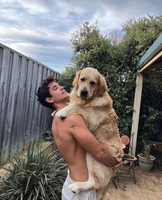 a man holding a large dog in his arms