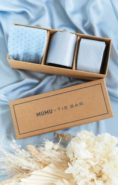 the box contains two pairs of mum - tie bar ties, one in blue and one in white