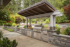 an outdoor kitchen with grill and seating area