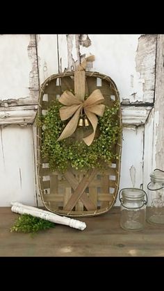 a basket with a bow on it sitting next to jars and other items in front of an old door