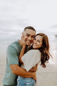 a man and woman hugging on the beach