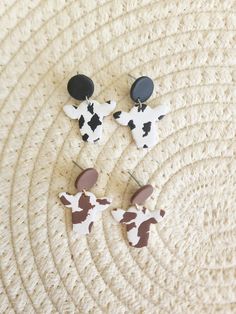 "Clay Cow Dangle Earrings. Choose from black or brown.  Handmade with a bit Of Hope and Clay, these earrings are perfectly imperfect, as each pair of earrings is uniquely made.  Message me about custom and/or bulk orders!  *All metal findings and posts on earrings are made from nickel free stainless steel or plated brass (or sterling silver if applicable). *Even though \"nickel free\" jewelry is labeled hypoallergenic I cannot promise 100% hypoallergenic materials due people having different levels of sensitivity to different materials. *Colors of actual product may differ slightly from listing pictures. I do my best to capture the actual color of the product in the listing photos. *Because they are handmade some minor imperfections and differences may apply, but that's what makes them uni Clay Cow, Cow Earrings, Brown Cow, Nickel Free Jewelry, Black Cow, Tucson Az, Perfectly Imperfect, Jewelry Earrings Hoops, Free Jewelry