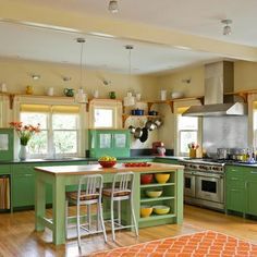 a kitchen with green cabinets and an island in front of the stove top oven is shown