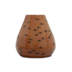 a brown vase with an eye pattern on it