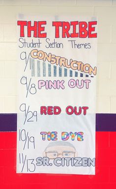 a sign on the side of a building that reads, the tribe student section themes construction pink out red out the day