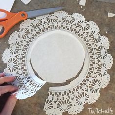 a person cutting out paper with scissors on a table