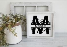 a white frame sitting next to a potted plant