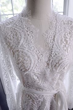 Very lovely robes, sheer lace fabric, will be perfect for wedding or honeymoon, or photoshoot. The lace fabric is very delicate, it looks pretty but fragile, iron/steam it with very low heat, handwash it and hang dry. Don't use high heat, or you'll burn the fabric. Size: Free size M can fit most, which would be good for hips measurements under 40 inches. if you need plus size, we can do that, please contact My height 5'4, 34 inches on me is mid thigh length Note: Please know each robe is handmad V-neck Lace Gown With Lace Trim, Lace Wedding Night Gown With Lace Back, Lace Back Gown For Wedding Night, Lace Wedding Night Robe With Lace Sleeves, Fitted Wedding Robe With Lace Sleeves, Long Lace Robe For Wedding Night, Fitted Lace Sleeves Wedding Robe, Fitted Lace Wedding Robe, Fitted Lace Robe For Wedding Night