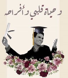 a man in a graduation cap and gown holding up his hands with flowers around him