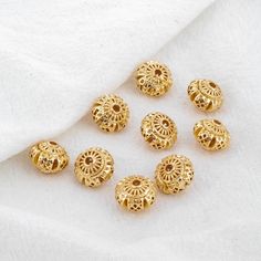 gold plated metal beads on white fabric