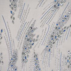 an embroidered fabric with blue and silver beads