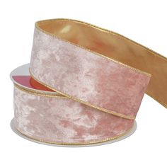 a pink and gold velvet ribbon with metallic foil on the edge, in front of a white background