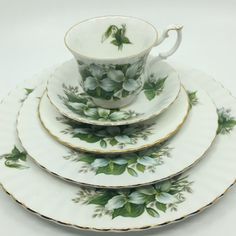 four plates with green leaves on them and one has a coffee cup in the middle