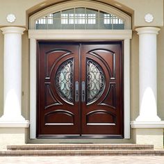 the front door to a house with two double doors on each side and pillars around it