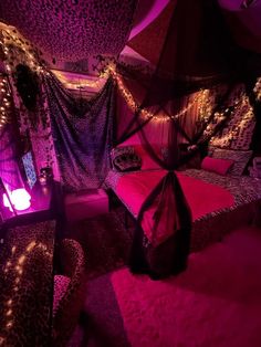 a bedroom decorated in purple and leopard print with lights on the ceiling, canopy bed