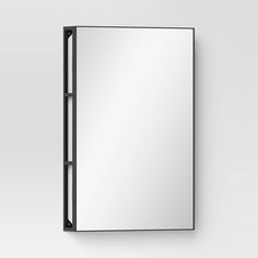 a mirror mounted to the side of a wall next to a light switch on a white wall