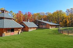 an image of a farm house in the middle of trees and grass with fall colors