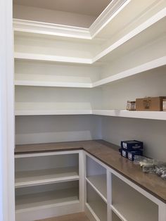 an empty walk in closet with shelves and boxes on the counter top next to it