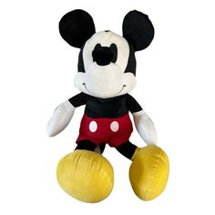 a mickey mouse stuffed animal sitting on top of a yellow ball