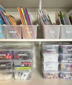 the shelves are filled with plastic containers and supplies for children's arts and crafts