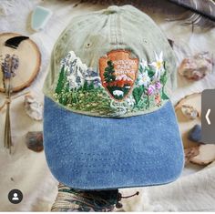 a baseball cap with an embroidered patch on it sitting on top of a table next to other items