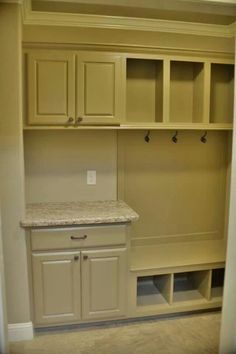 an empty mud room with cabinets and marble counter tops