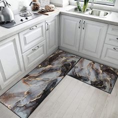 a kitchen with white cabinets and marble flooring in the middle, along with an area rug that looks like it has been cut open