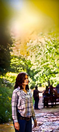 a woman standing in the middle of a park