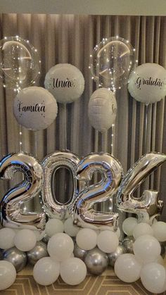 the balloons are in the shape of numbers and some white balls on the table with them