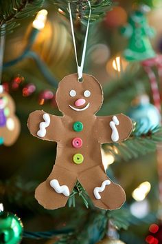 a christmas ornament hanging from a tree decorated with buttons and icing on it