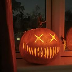 a carved pumpkin sitting on top of a window sill