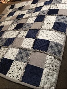 a blue and white quilt is laying on the floor