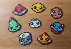 six perler beads are arranged in the shape of cartoon characters on a wooden surface