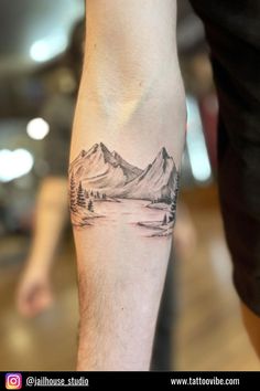 a man with a mountain tattoo on his arm