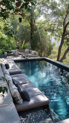 an outdoor pool with lounge chairs and trees in the background