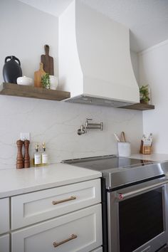 a stove top oven sitting inside of a kitchen next to a wall mounted range hood