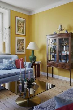 a living room with yellow walls and furniture