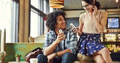 a man sitting next to a woman talking on a cell phone while holding a smart phone