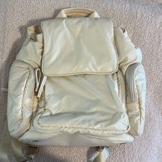 a white backpack laying on the floor